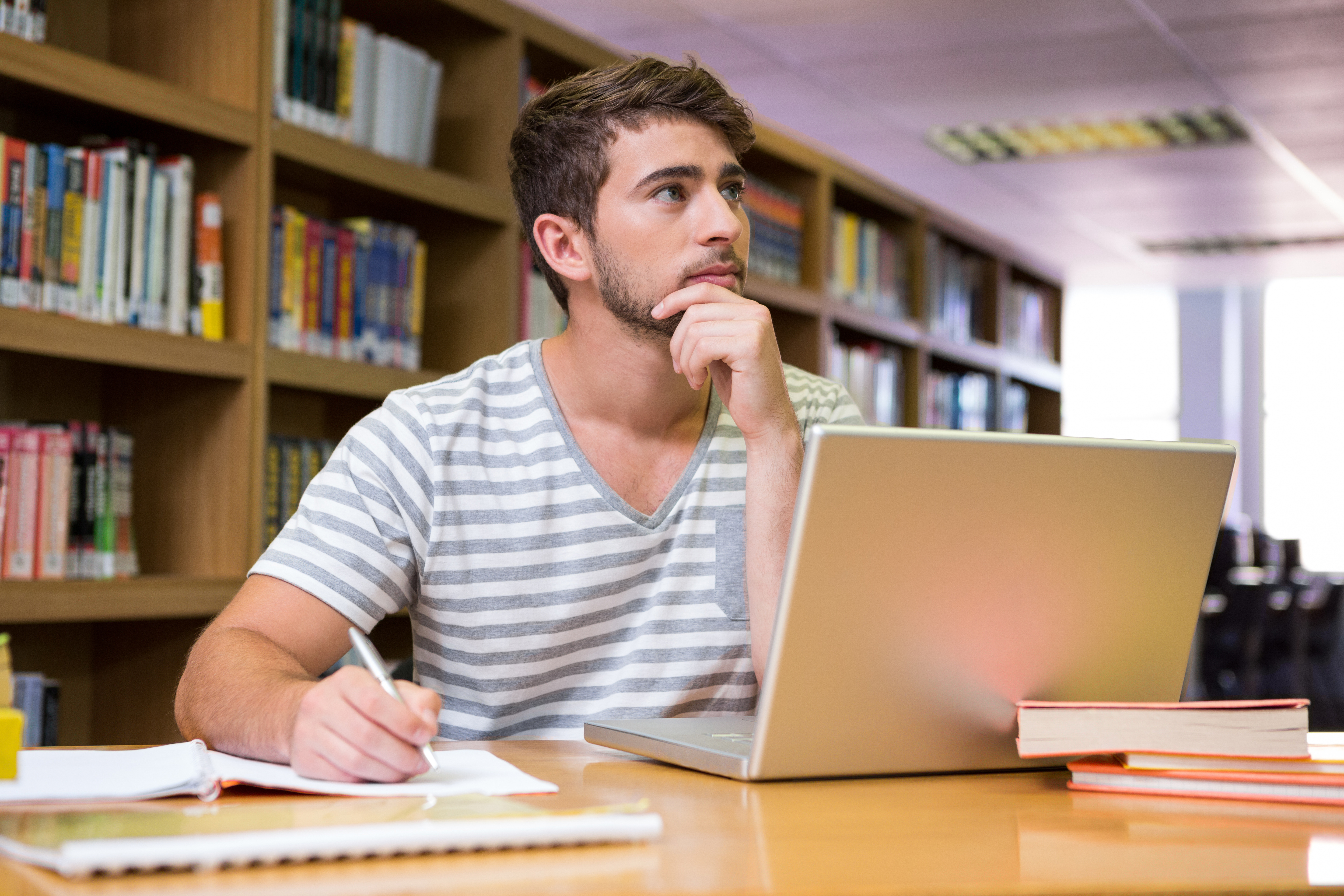 Additional support. Учеба в библиотеке. Студент с ноутбуком. Мужчина в библиотеке.